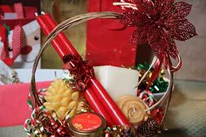 a christmas gift basket filled with pure beeswax candlesticks and pine cone candles and rose candles