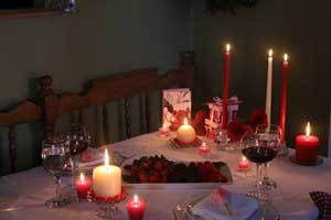 Valentine's Day dinner table set with red and white pure beeswax taper candles, pillar candles and tealight candles.