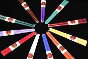 beeswax taper pair candles laid out in a color circle . The candles are red, teal, yellow, orange, white, blue, green and brown