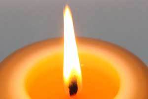 close up shot of brightly burning flame on a pure beeswax candle
