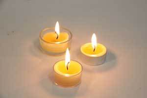 three burning pure beeswax tealight candles 