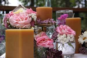 pure beeswax pillar candles with large pink and white flowers on a table 