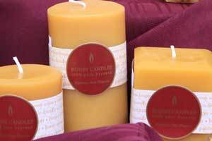 three natural beeswax pillar candles with the Honey Candles logo