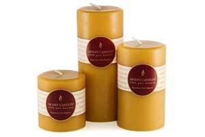 a grouping of natural beeswax pillar candles in 3 , 5 and 7 inch height