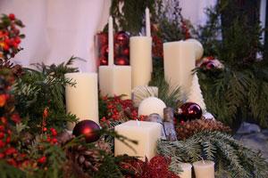 White Beeswax Candles in front of a Christmas setting