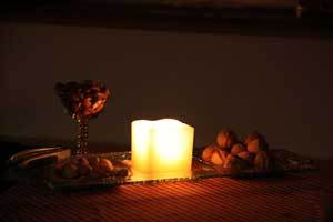 a beautiful glowing beeswax pillar candle on a table centerpiece plate with snacks