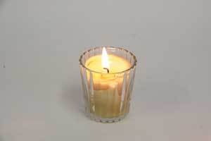 Natural beeswax votive candle in a glass holder