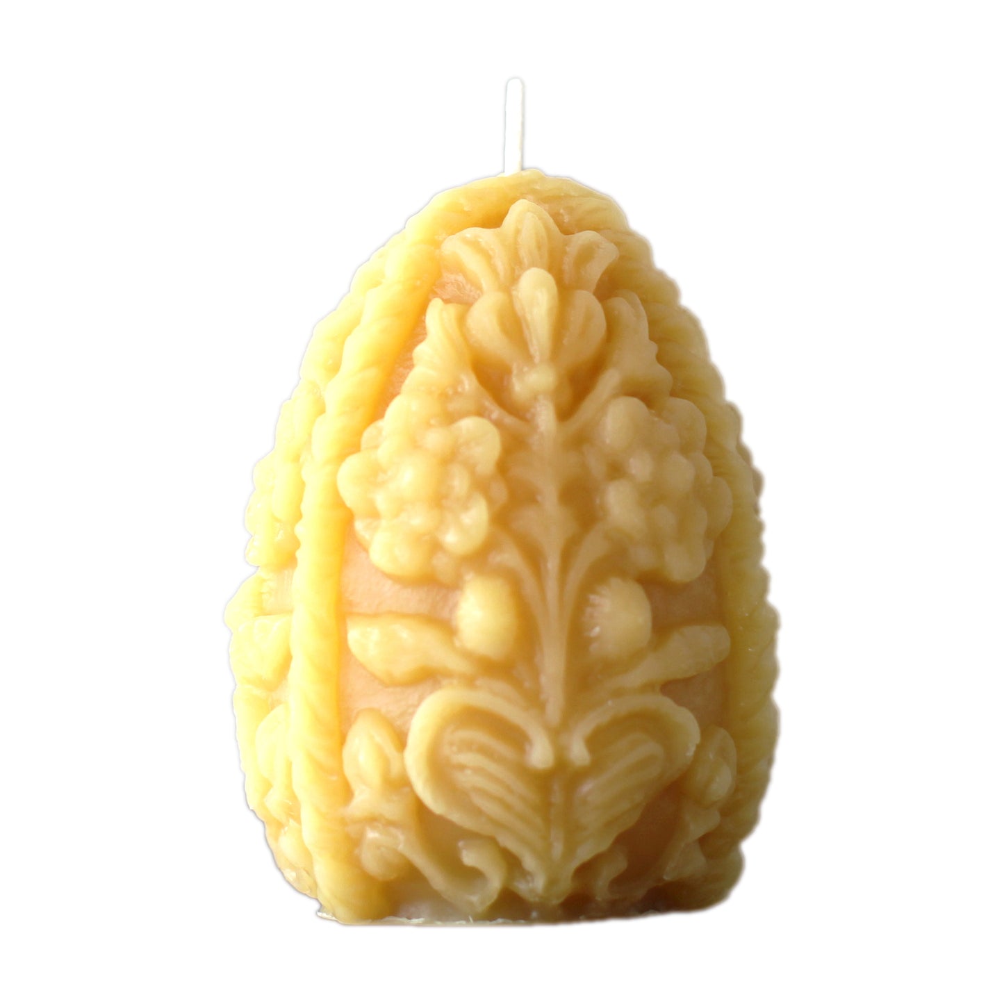 A product photo of a beeswax Easter egg shaped candle on a white background. The egg candle has an ornate decorative design.