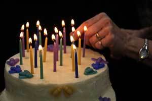 20 colorful beeswax  candles on a white cake celebrating Honey Candles' 20th anniversary