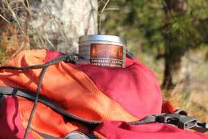 pure beeswax emergency tin candle on a hiking back pack in the forest