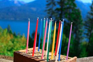 pure beeswax colorful gala candles in a sandbox with mountains in the background