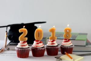 pure beeswax number candles in cupcakes in front of a graduation cap