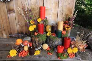 multiple styles and shapes of beeswax candles in fall colors red, tangerine (orange) and brown