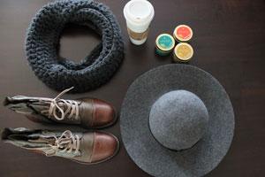 beeswax essential tin candles with a hat, pair of shoes, a scarf and a cup of coffee