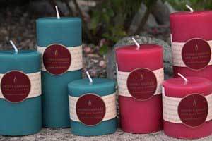 a group of Teal and Pink pure beeswax round pillar candles with Honey Candles logo