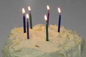 White birthday cake with six pure beeswax birthday candles