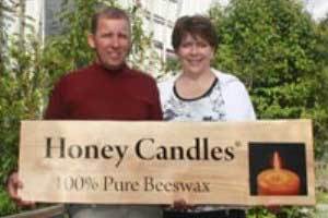 Honey Candles owner holding a Honey Candles sign