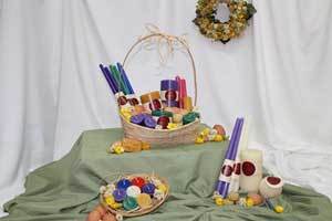 an Easter basket over flowing with pure beeswax  candles in beautiful colors, purple, green, natural , white