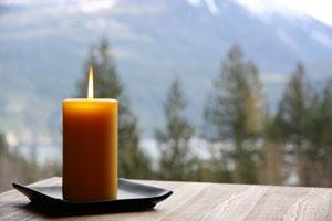 a pure beeswax pillar candle on a table with the mountains in the background