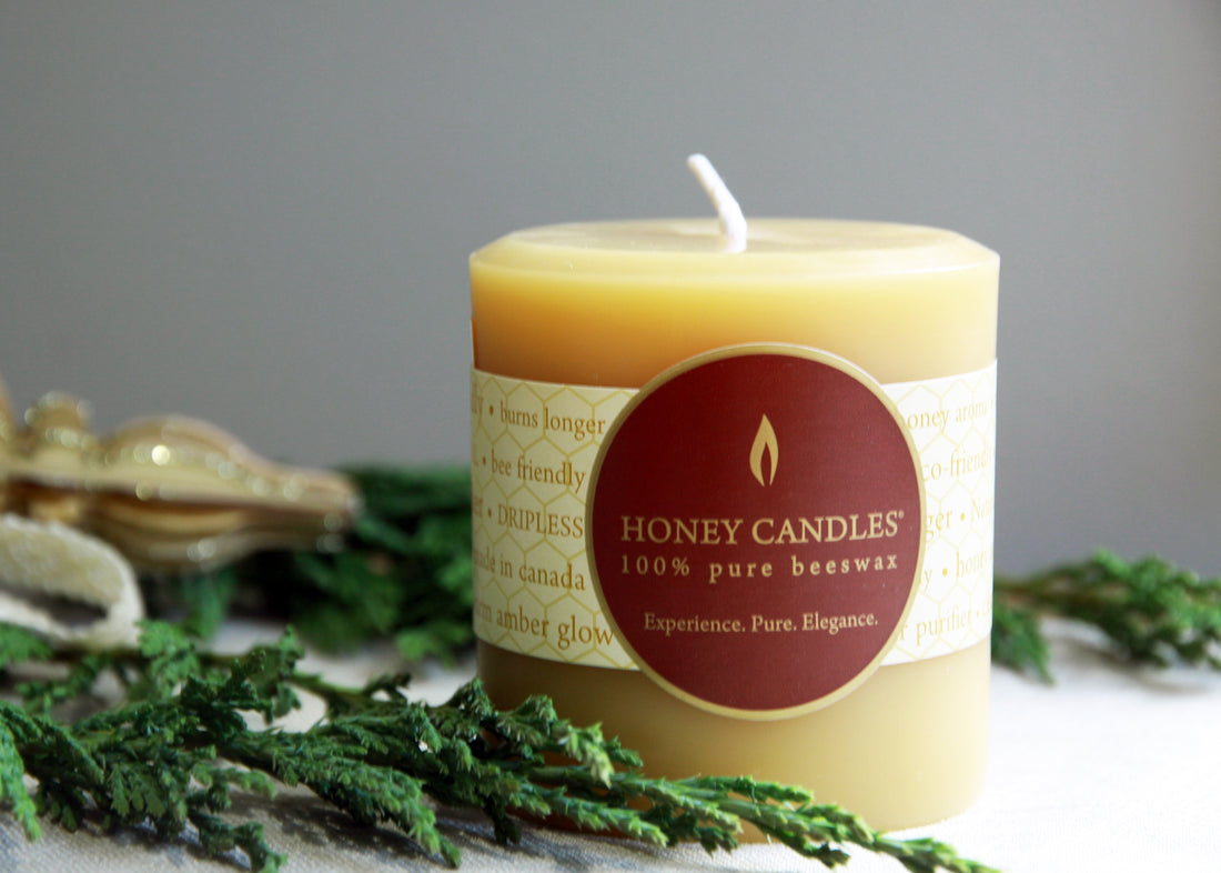 A pure bees wax pillar candle with greenery 