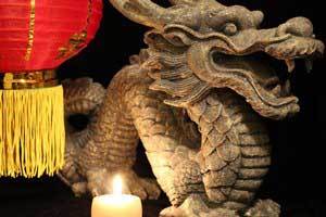 pure beeswax candle burning in front of a Chinese dragon
