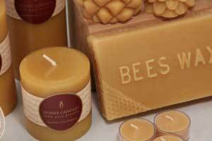 close up of natural beeswax pillar candle and a block of beeswax