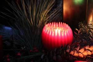 a glowing red pure beeswax fluted sphere candle