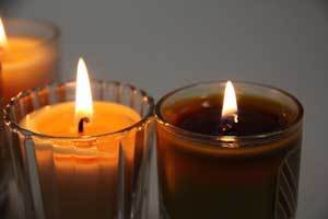 a soy candle and pure beeswax candle burning side by side showing how the beeswax candle's flame was larger and the candle burned longer