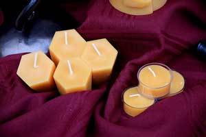 pure beeswax hexagon votive candles and tealight candles on a burgundy cloth