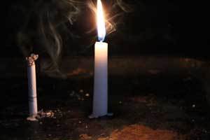 a paraffin candle burning next to a cigarette