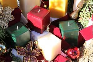 beautiful red, green and white pure beeswax square pillar candles on a Christmas table setting 