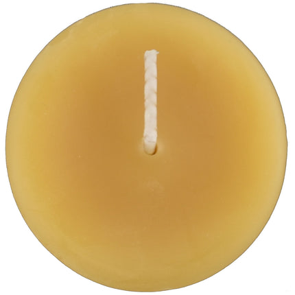 The top of a natural beeswax votive candle and wick, golden yellow in color, with a soft honey scent