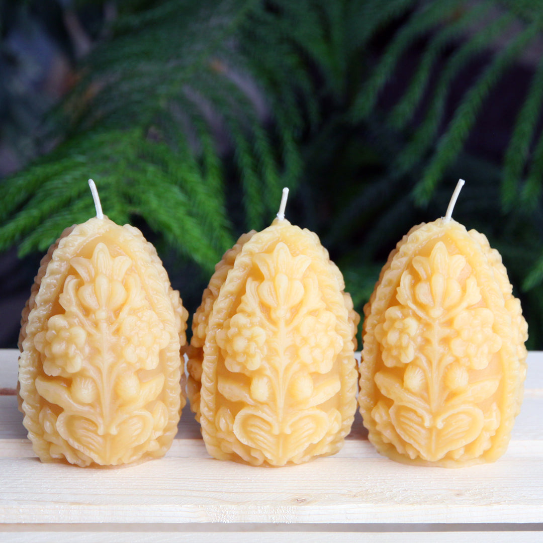A trio of decorative beeswax egg shaped candles